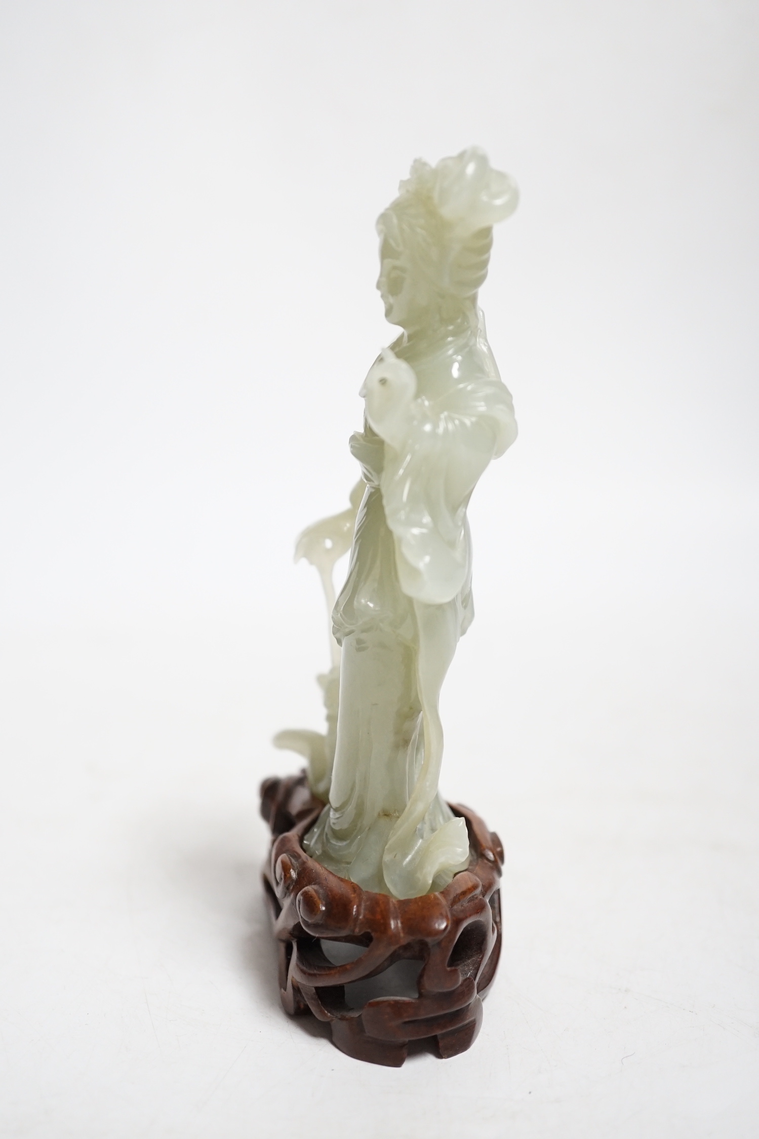 A Chinese celadon jade figure of a lady, on wood stand, 13cms high.